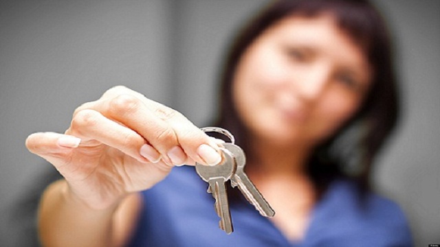 Realtor is giving the keys to an apartment to some clients. focus on the keys